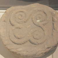 a rock with a spiral rune carved on the surface